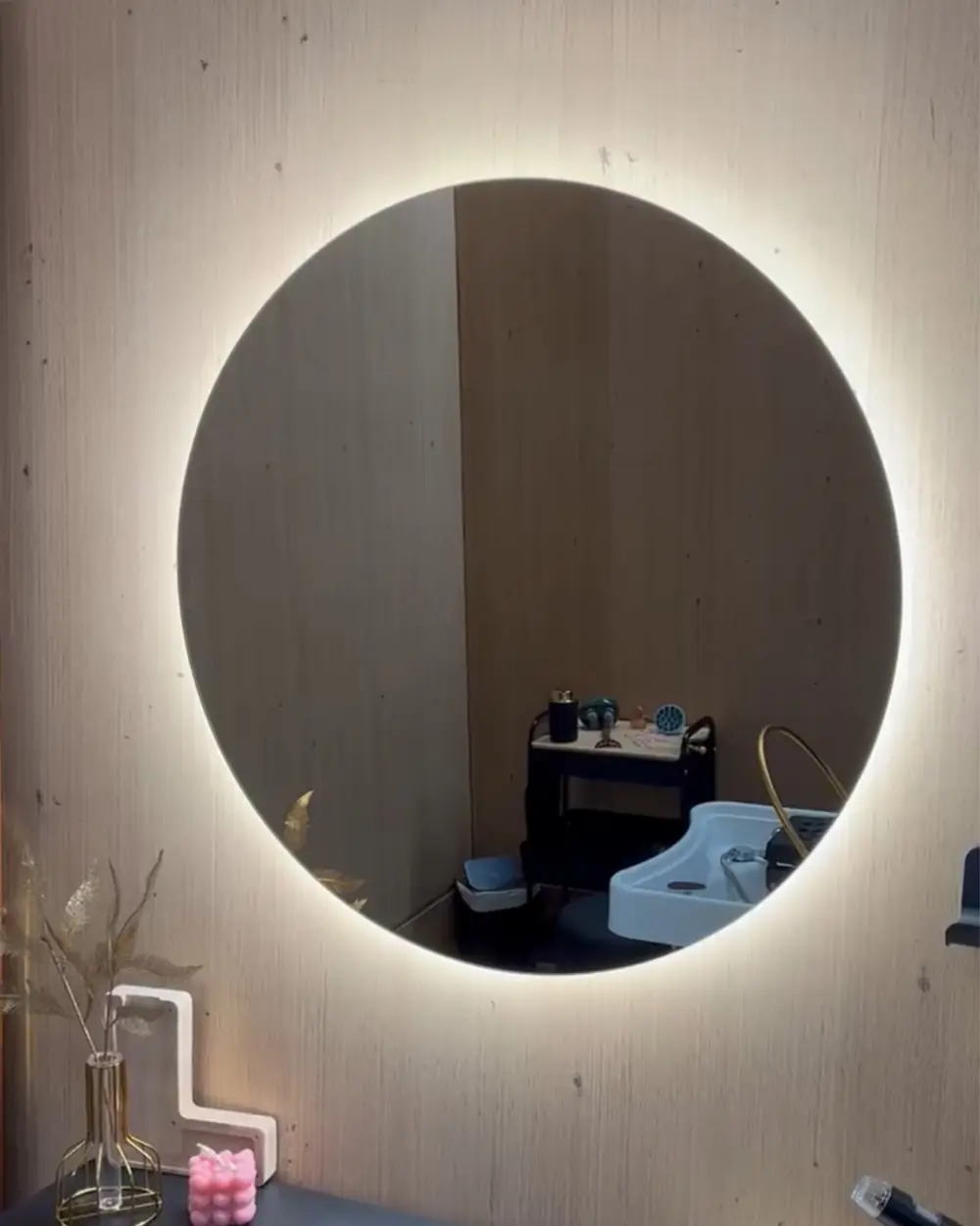 Tocador de Centro Ónix con espejo redondo iluminado y paredes de madera clara