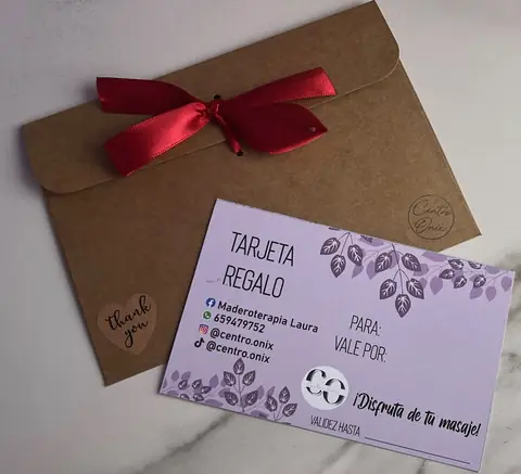 Tarjeta regalo lila de Centro Ónix con hojas dibujadas, sobre un sobre kraft con lazo rojo y la pegatina thank you
