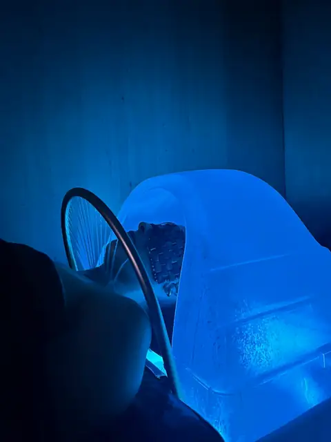 La cúpula de vapor del spa capilar iluminada en azul sobre el lavacabezas, con gotas de condensación